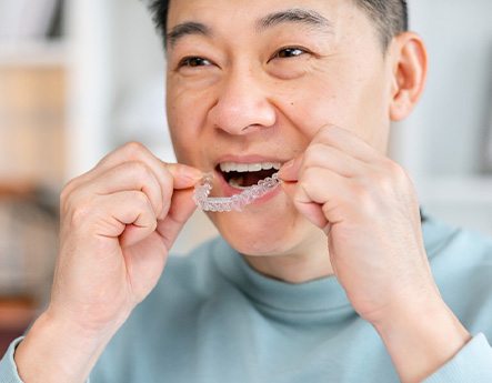 Patient putting on clear aligner