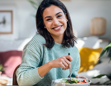 Woman in waffle sweater eating salad