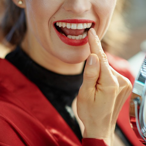 Woman in Lewisville looking at her cosmetic dental bonding