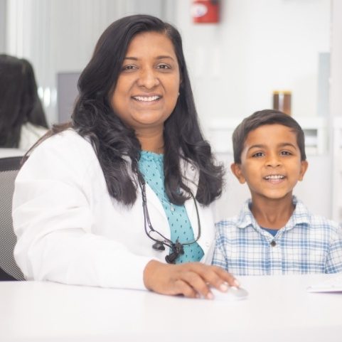 Young dental patient pointing to smile during children's dentistry visit