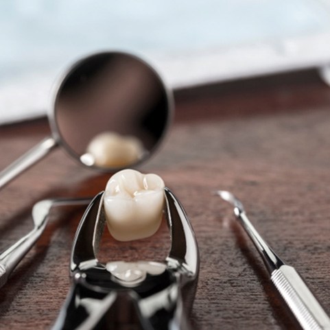 Close-up of forceps and tooth after tooth extraction in Lewisville, TX