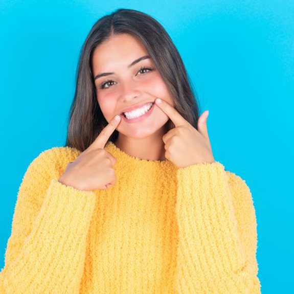 Happy woman pointing at her beautiful smile