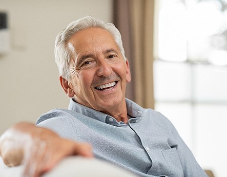 man smiling while sitting on couch 