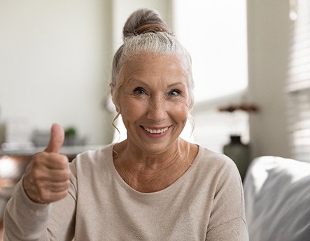 woman smiling and giving thumbs up 