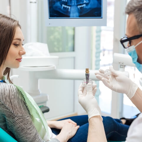 dentist and dental patient discussing the four step dental implant process