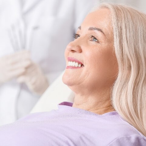 Woman with complete smile after tooth replacement with dental implants