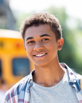 Young man smiling outside with plaid shirt