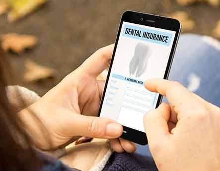 A woman looking at a dental insurance form on her phone