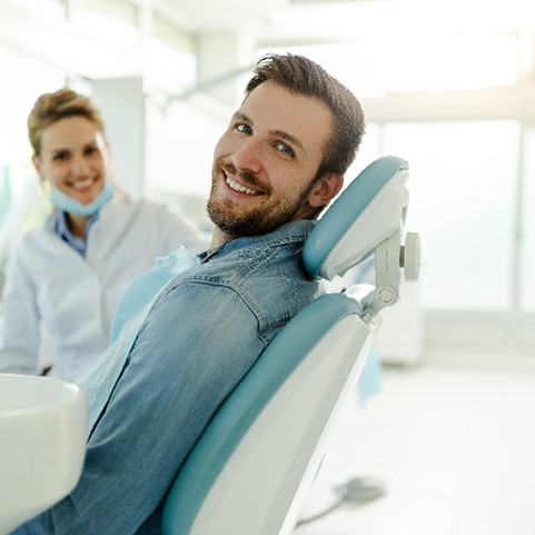 Man in denim shirt smiling while sitting in treatment chair