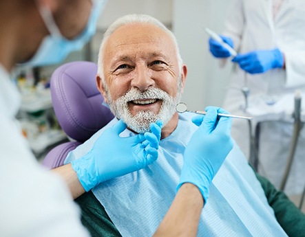 Senior man smiling at dentist during dental checkup