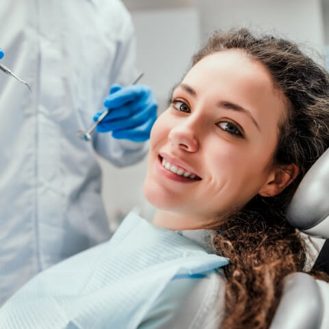 Woman smiling during dental checkup and teeth cleaning visit