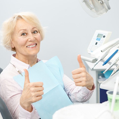 Senior female dental patient giving two thumbs up