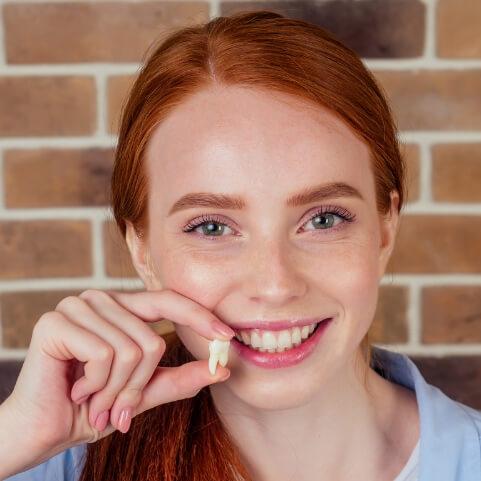 Woman holding an extracted wisdom tooth